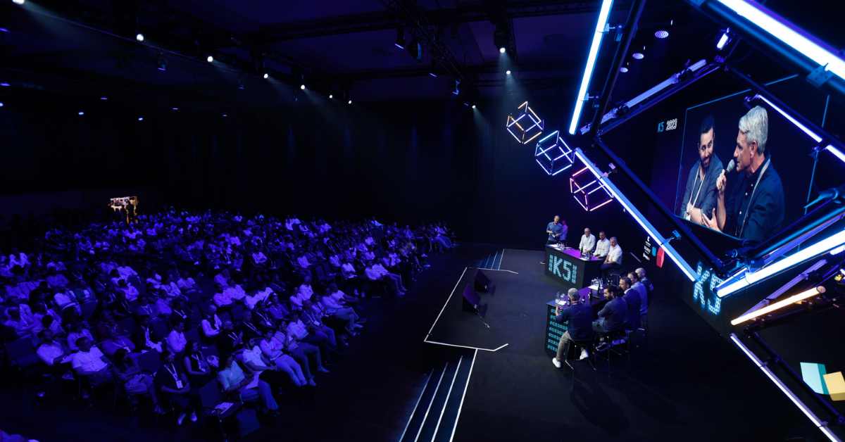Das Bild zeigt Speaker und Publikum auf und bei der Deep Dive Stage der K5 2023