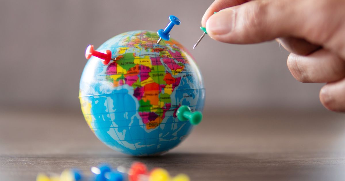 Ein Miniaturglobus mit einigen Pinnadeln, der f&uuml;r die Expansion im Onlinehandel steht